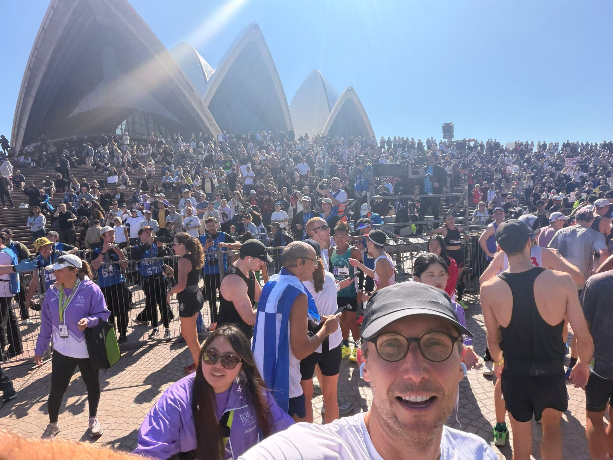 Riccardo Tessari at the finish of the 2026 TCS Sydney Marathon, Sydney Opera House in the background